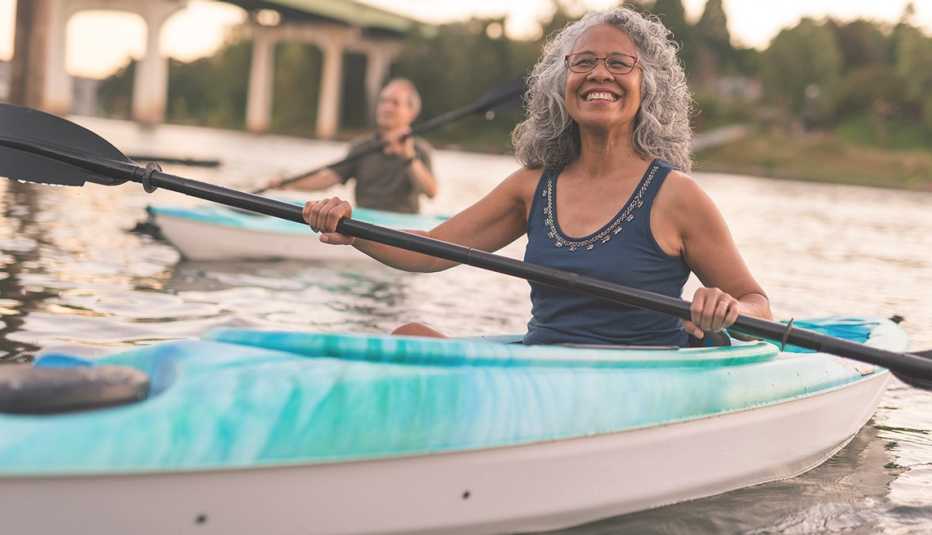 Una mujer y un hombre navegan en kayak en un lago