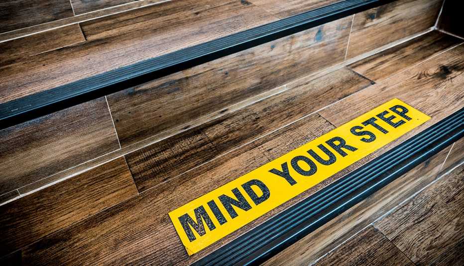 Rótulo en amarillo que advierte a las personas que tengan cuidado con el escalón Rótulo en amarillo que advierte a las personas que tengan cuidado con el escalón