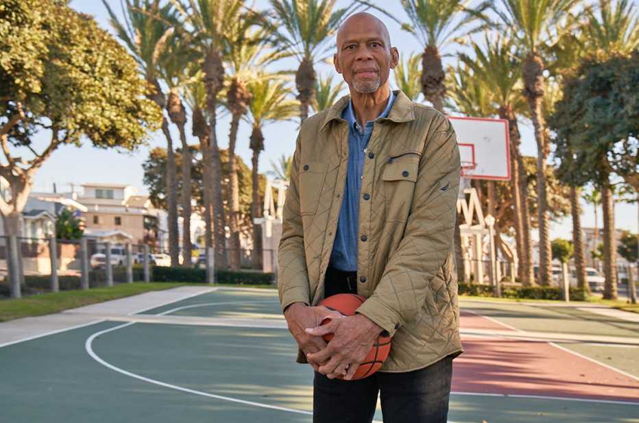Kareem Abdul-Jabbar en una cancha de baloncesto y con una bola en sus manos