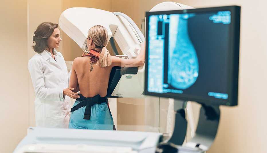 Un médico y una paciente durante una mamografía. Un médico y una paciente durante una mamografía.