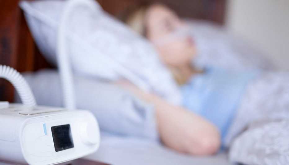 Ventilador artificial y paciente hospitalizado al fondo