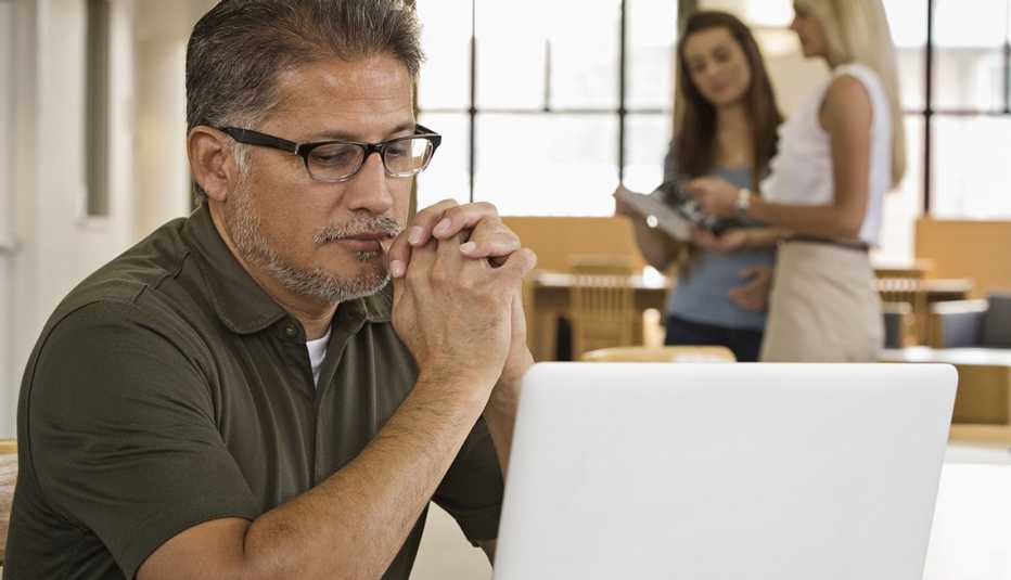 Hombre sentado frente a su computadora Hombre sentado frente a su computadora