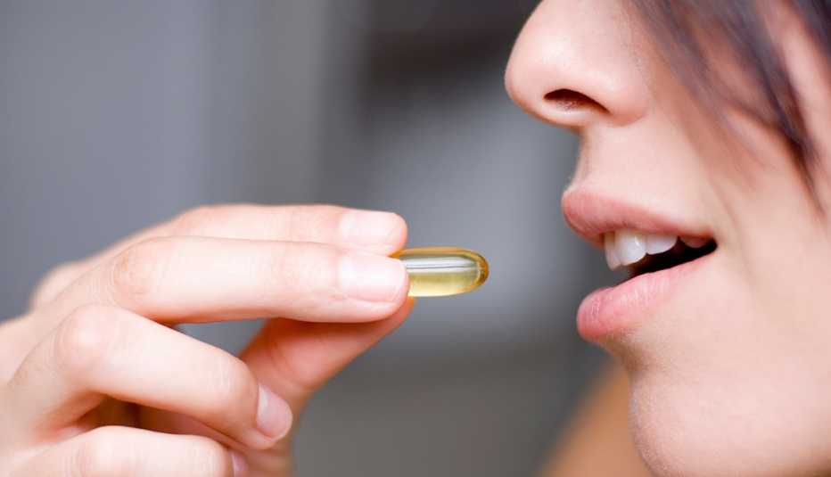 Mujer tomandose una vitamina