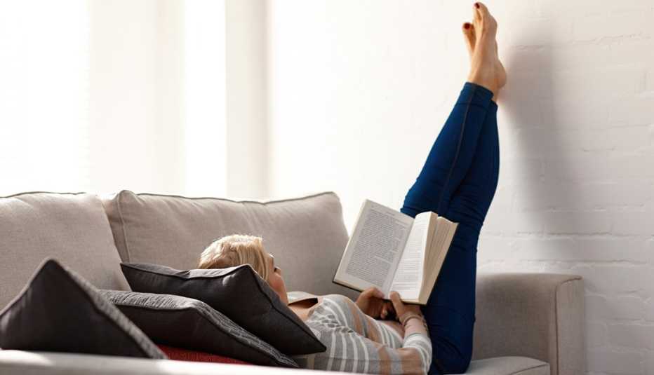 Mujer leyendo muy relajada en un sofá Mujer leyendo muy relajada en un sofá