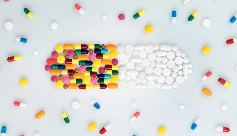 Píldoras de colores y blancas formando una gran píldora - Medicamentos que pueden causar cáncer Píldoras de colores y blancas formando una gran píldora - Medicamentos que pueden causar cáncer
