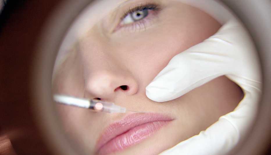 Médico inyectando los labios de una mujer - Estética Médico inyectando los labios de una mujer - Estética