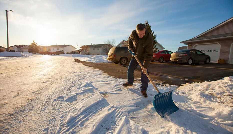 Un hombre paleando la nieve 