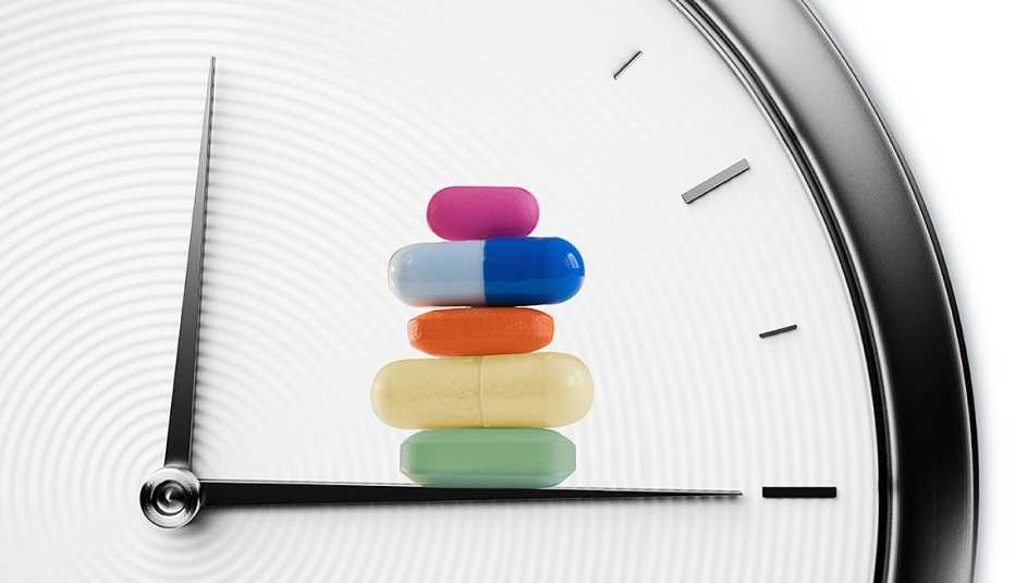 Reloj de fondo y pastillas sobre el minutero Reloj de fondo y pastillas sobre el minutero