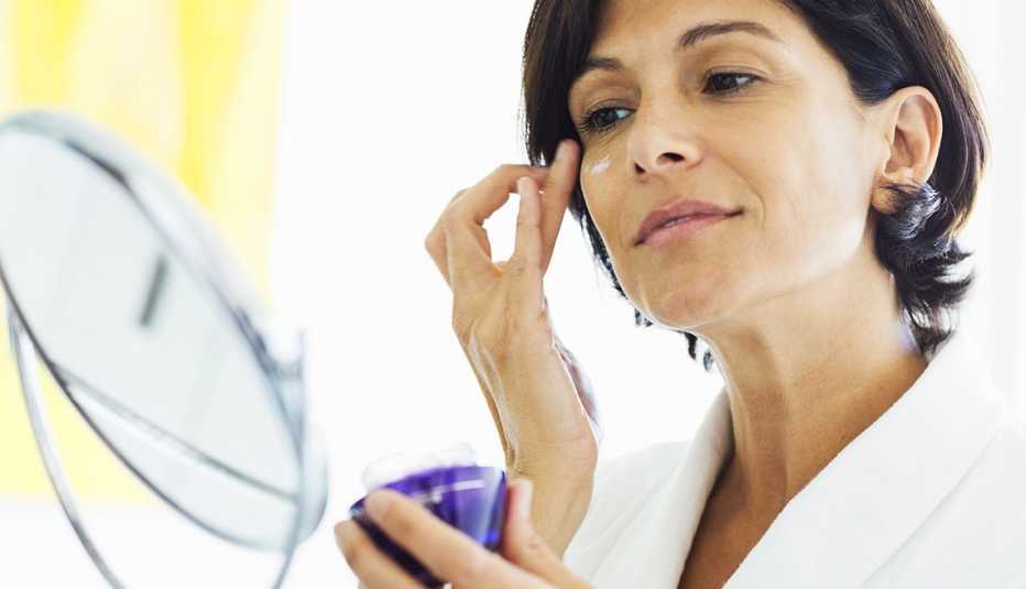 Mujer poniéndose crema en la cara