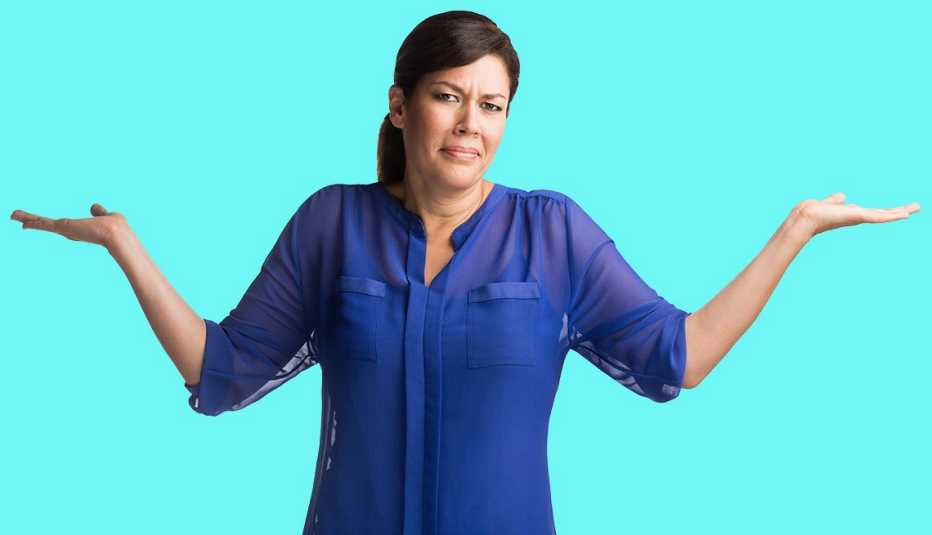 Mujer con cara de inconformidad abre los brazos mientras está de pie.