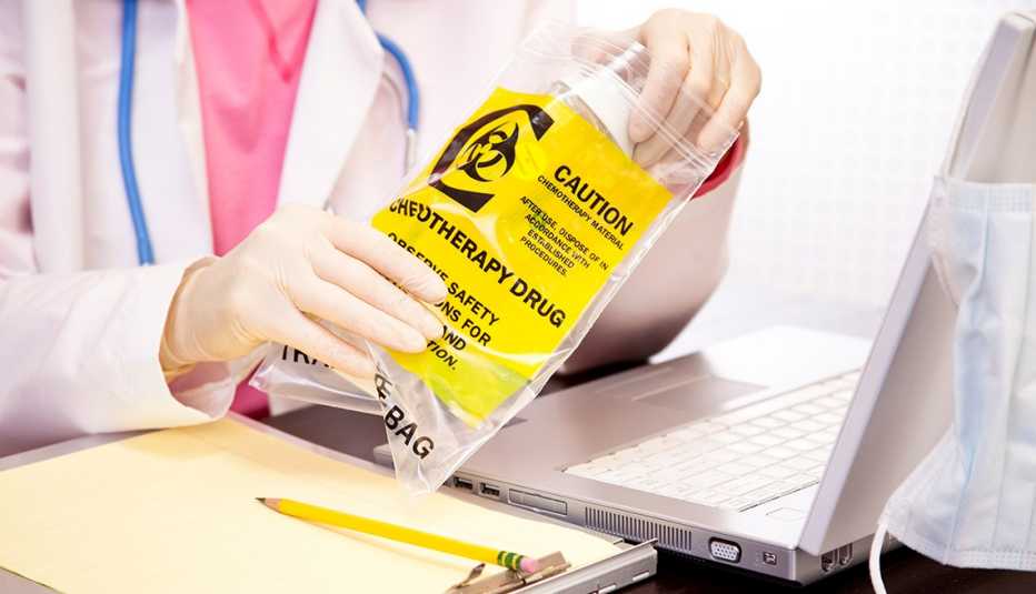 Un médico sostiene un medicamento para quimioterapia