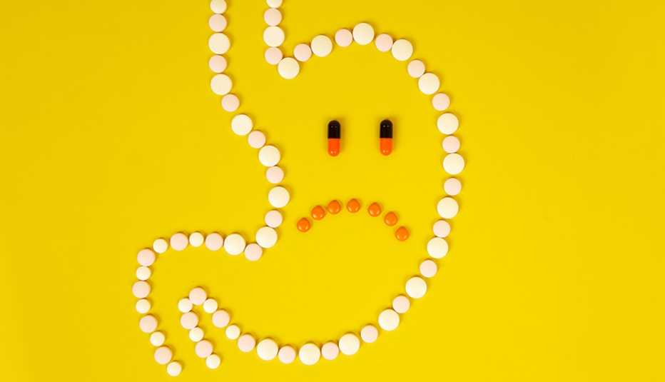 Un estómago formado por pastillas sobre un fondo amarillo