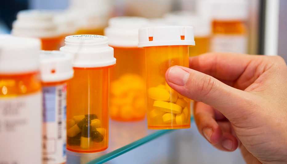 Persona sostiene un recipiente con medicamentos