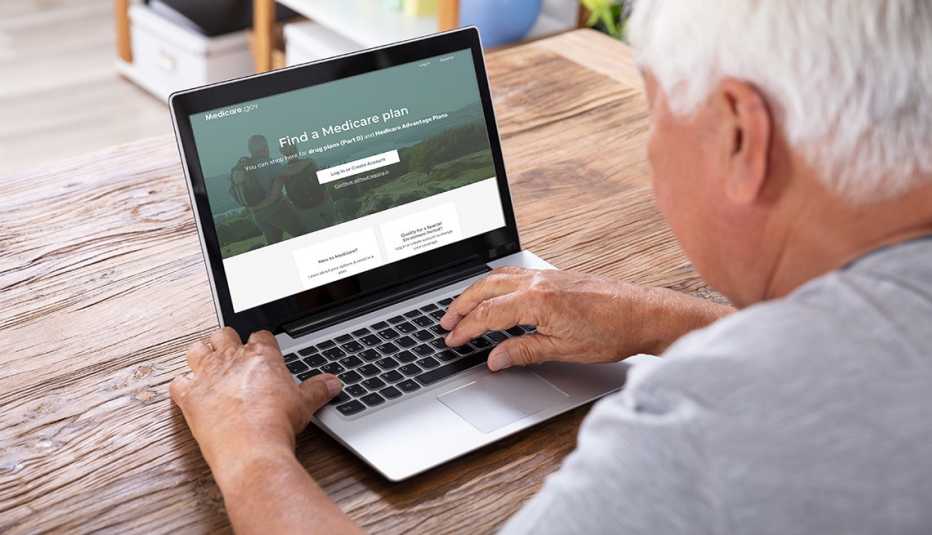 Un hombre busca información sobre Medicare en una computadora portátil