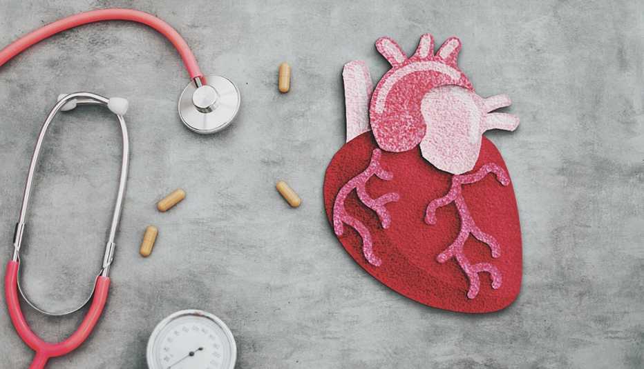 Un estetoscopio, pastillas y un corazán hecho en fieltro