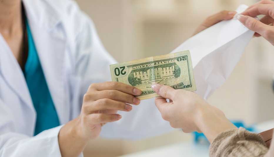 Mujer pagando en efectivo por sus medicamentos