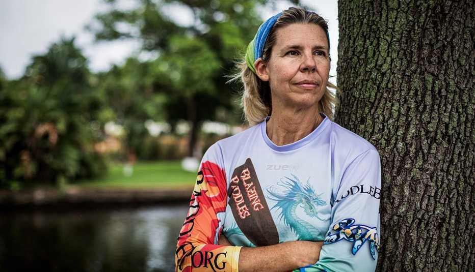 Mujer recostada de un árbol