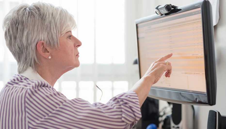 Mujer señala al monitor de su computadora Mujer señala al monitor de su computadora