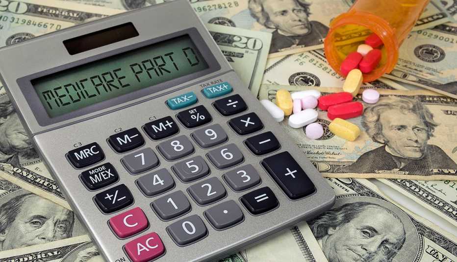 Calculadora sobre dinero y frasco de pastillas derramado