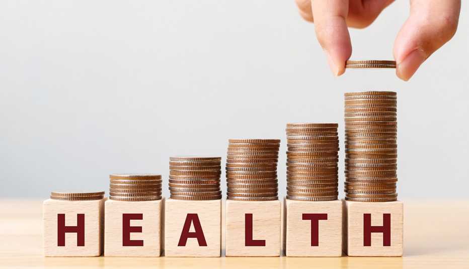 Monedas estibadas sobre bloques de madera que dicen "Health"