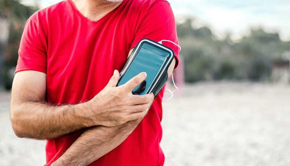 Un hombre pone música en su teléfono móvil