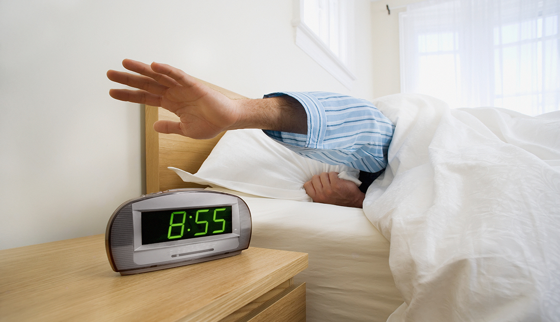 Hombre apagando su reloj despertador