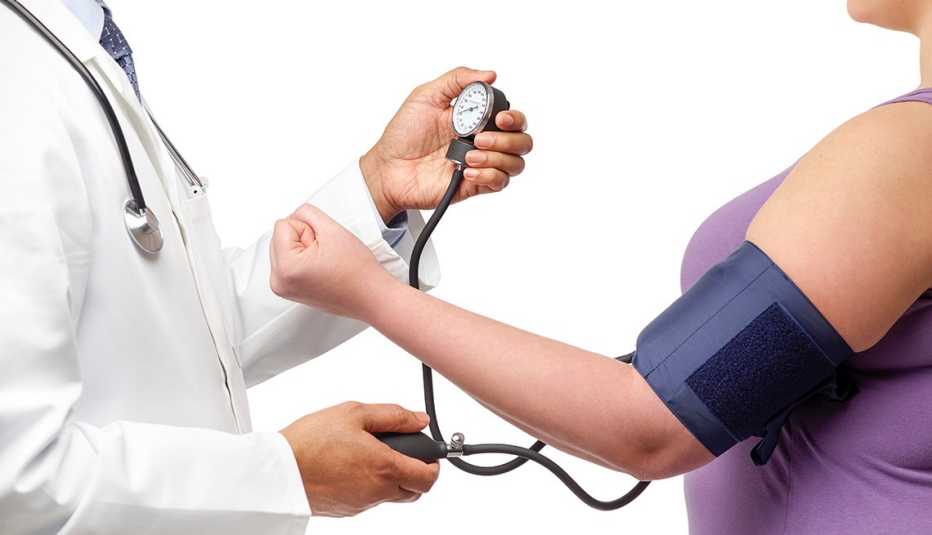Doctor midiendo la presión de una mujer