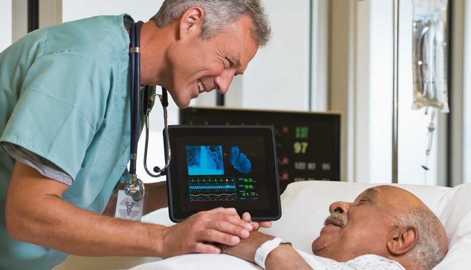 Un doctor se inclina para hablar con un paciente