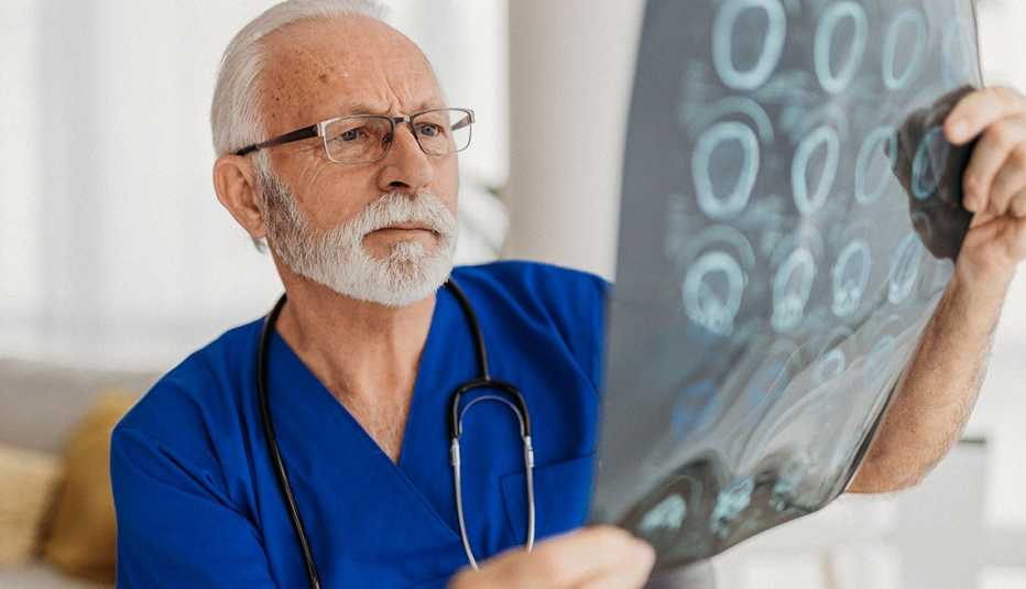 Un médico analiza unas radiografías del cerebro de un paciente Un médico analiza unas radiografías del cerebro de un paciente