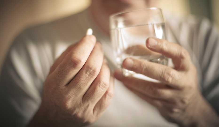 Una persona mayor tomando un medicamento Una persona mayor tomando un medicamento