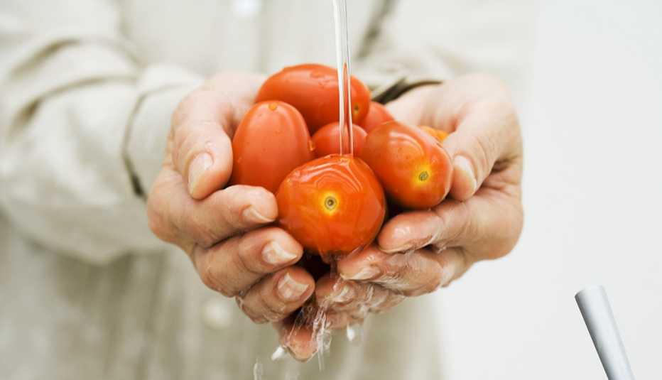 Mujer lavando unos tomates Mujer lavando unos tomates