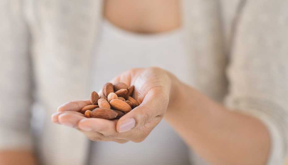 Mujer con almendras en su mano