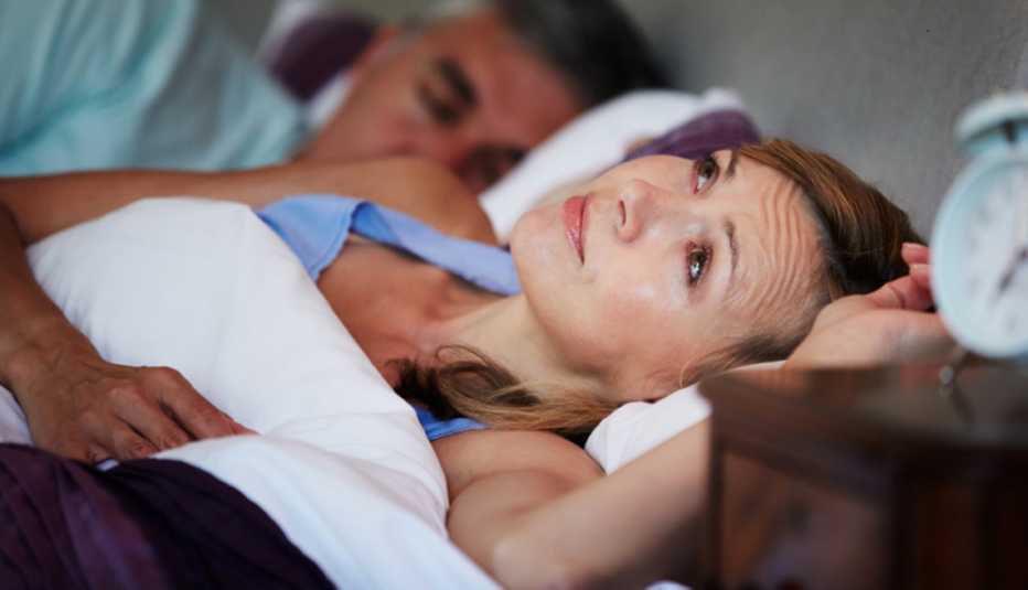 Mujer acostada sin poder dormirse