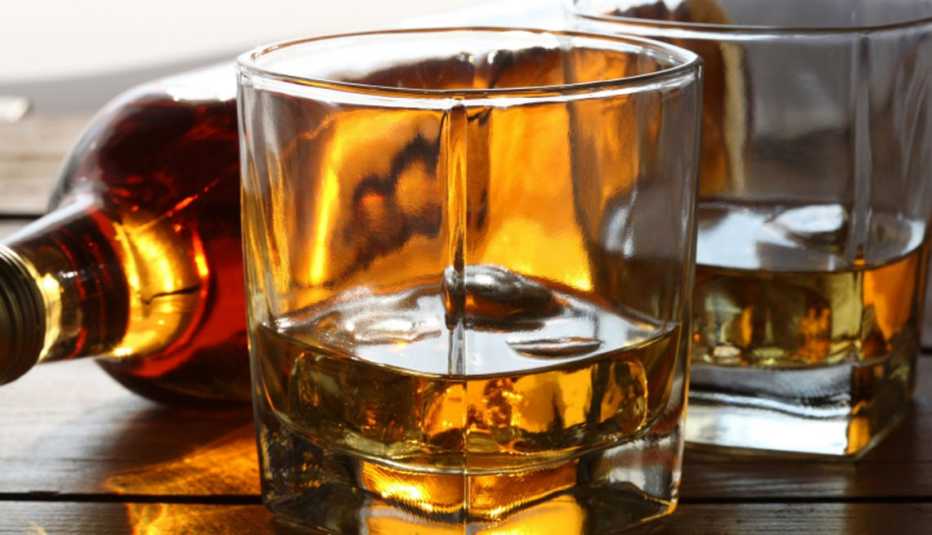 Botella de whiskey y vasos servidos