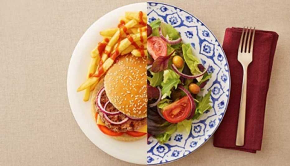 Mitad hamburguesa con papas fritas y la otra mitad ensalada
