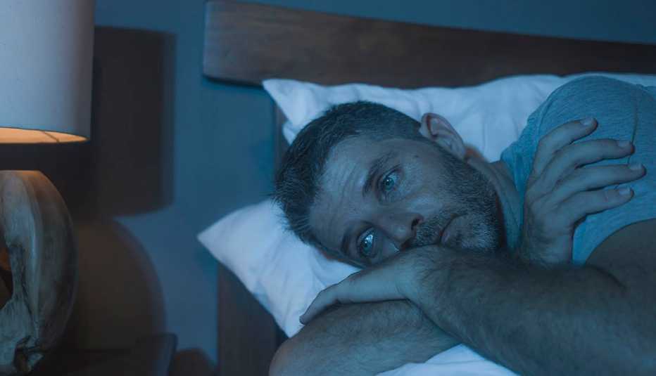 Un hombre en su cama despierto y triste