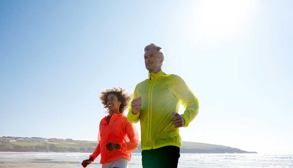 Pareja corriendo en la playa