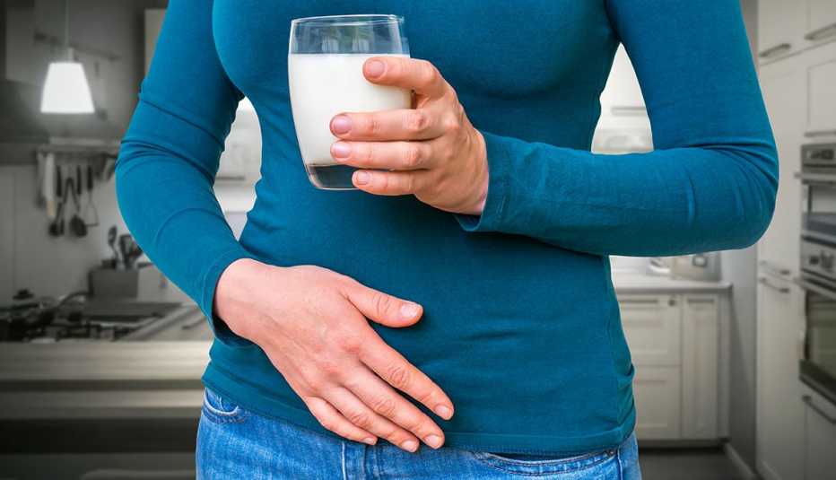 Mujer con una mano en la barriga y otra sostiene un vaso Mujer con una mano en la barriga y otra sostiene un vaso