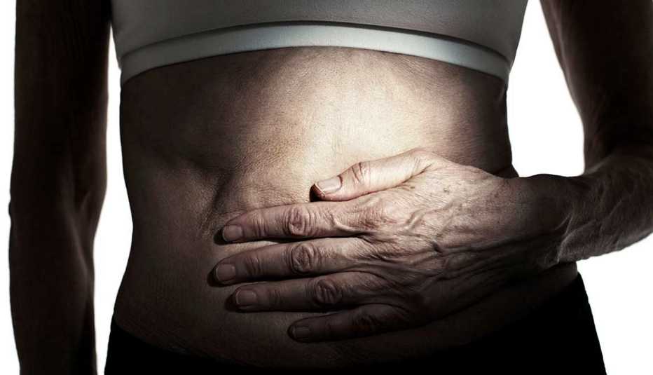 Woman holds sore stomach, Foods that help the gut