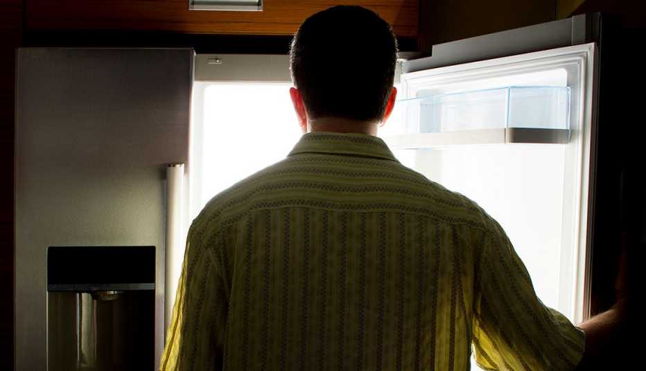Hombre parado frente al refrigerador Hombre parado frente al refrigerador