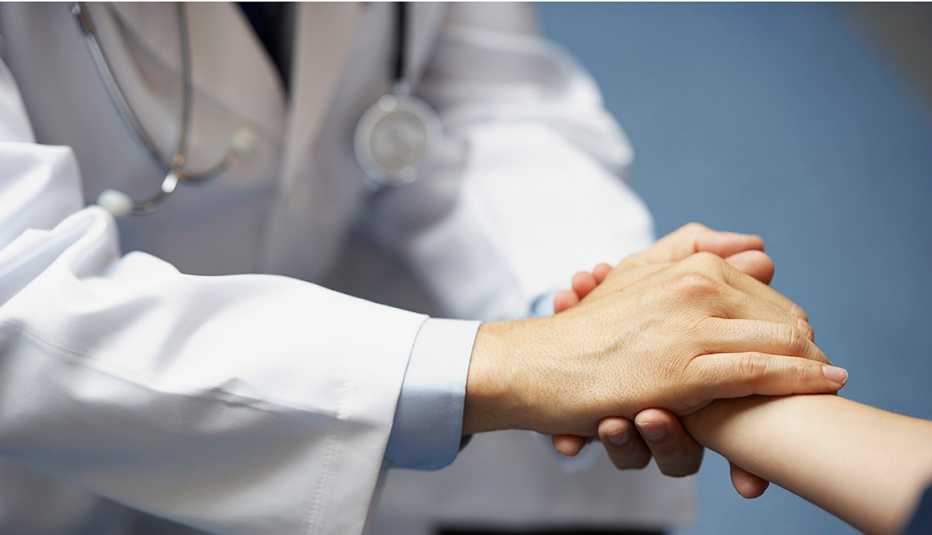 Médico toma la mano de su paciente