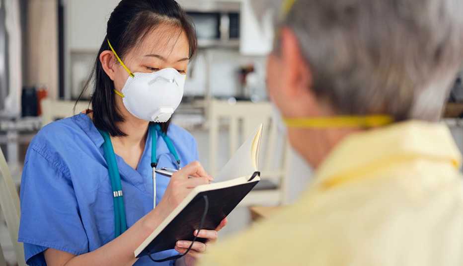 Una doctora toma notas de un paciente