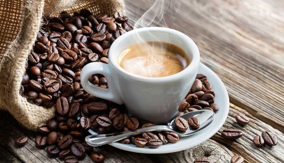 Taza de café rodeada de granos de café Taza de café rodeada de granos de café