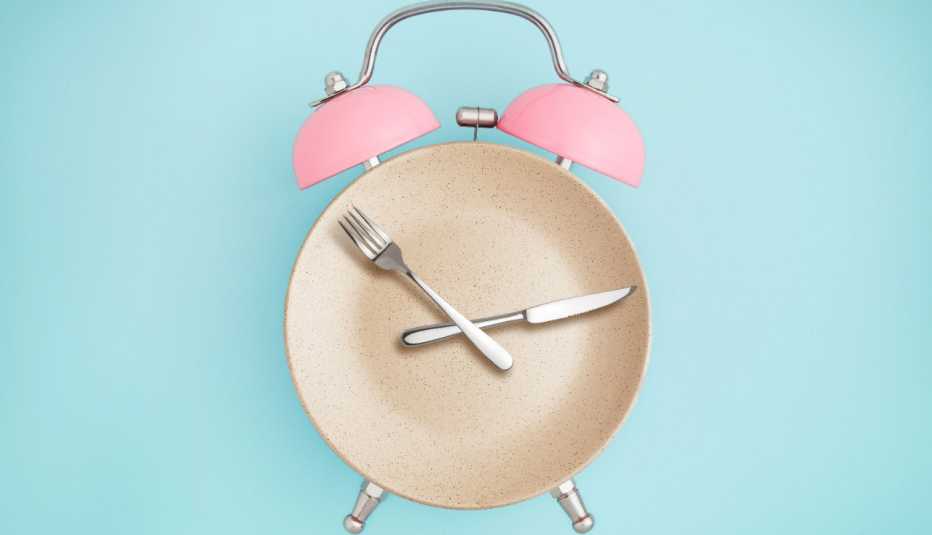 Reloj alarma y la parte redonda es un plato, cubiertos son las manecillas Reloj alarma y la parte redonda es un plato, cubiertos son las manecillas