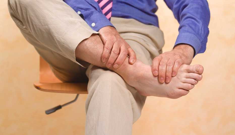 Un hombre masajea uno de sus pies