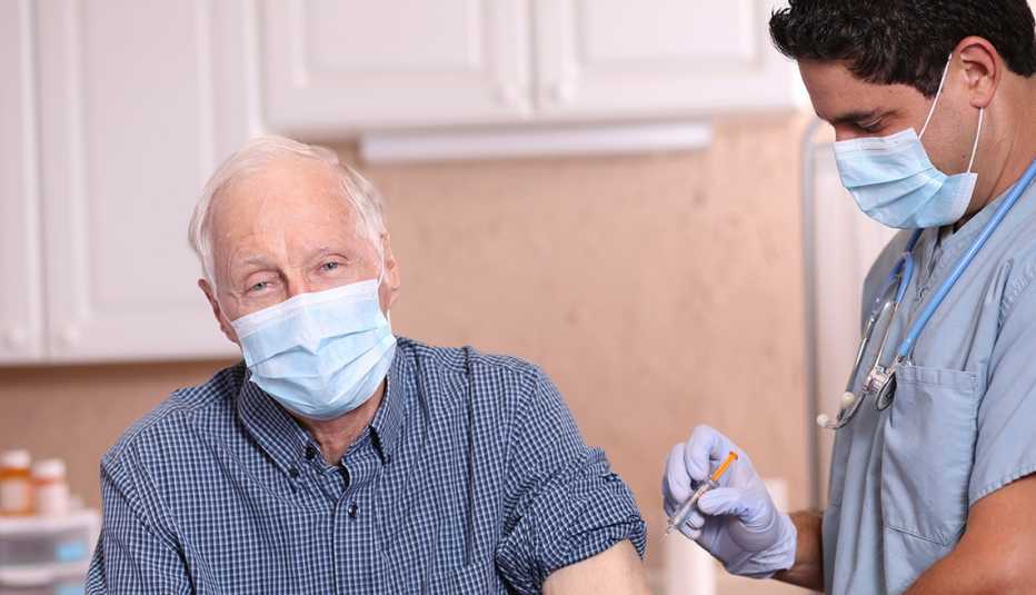 Médico le pone una vacuna a un paciente