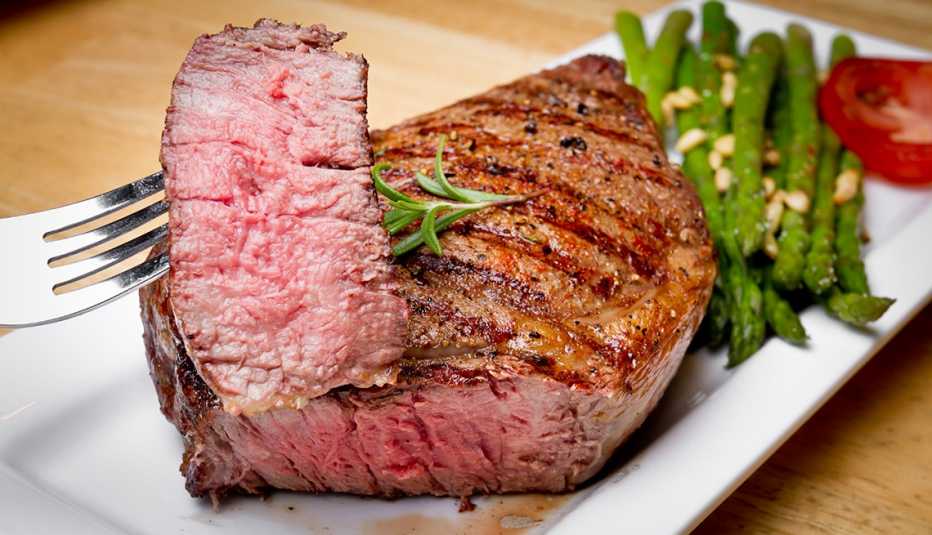 Un filete de costilla cocinado a medio término, acompañado por espárragos