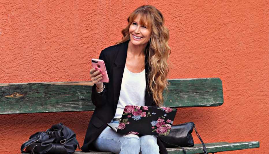 Lorraine Ladish sostiene en la mano un teléfono móvil