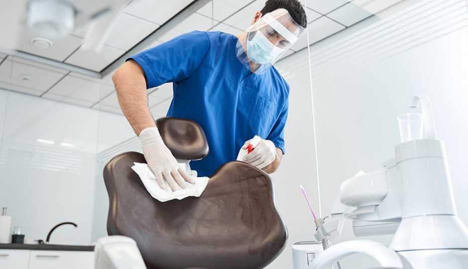 Higienista dental desinfecta una silla Higienista dental desinfecta una silla