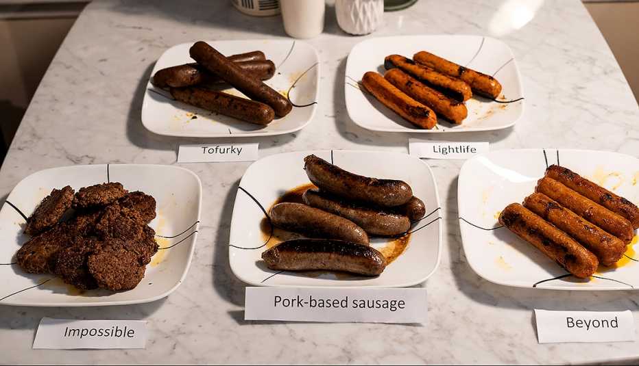 Cinco platos con cinco diferentes salchichas veganas y de cerdo